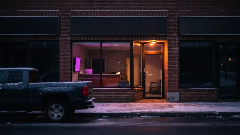 Small dental office storefront on a New England main street at dusk, a Central Massachusetts setting for an AI receptionist