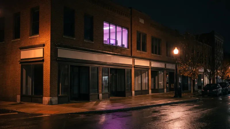 Lit upstairs office window on a New England main street at night, a Central Massachusetts business starting MDR